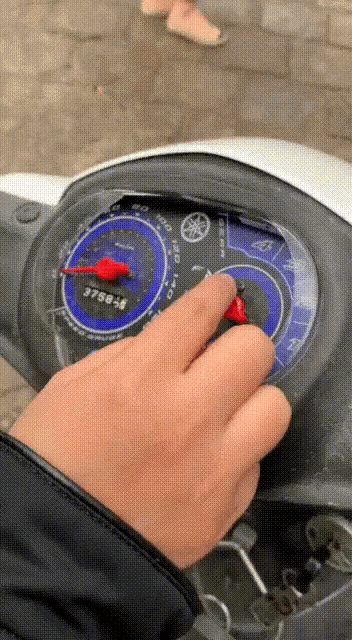 a close up of a person 's hand on a yamaha speedometer