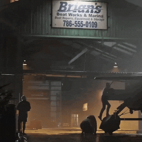 a sign for brian 's boat works & marina hangs above a garage door