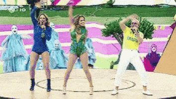 a group of people are dancing on a stage with a man in a yellow shirt that says brasil