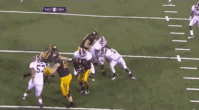 a football player with the number 5 on his jersey is being tackled by a group of players