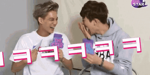 two men are laughing and one has the word star on his shirt
