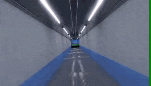a tunnel with a large screen on the wall that shows a soccer field .