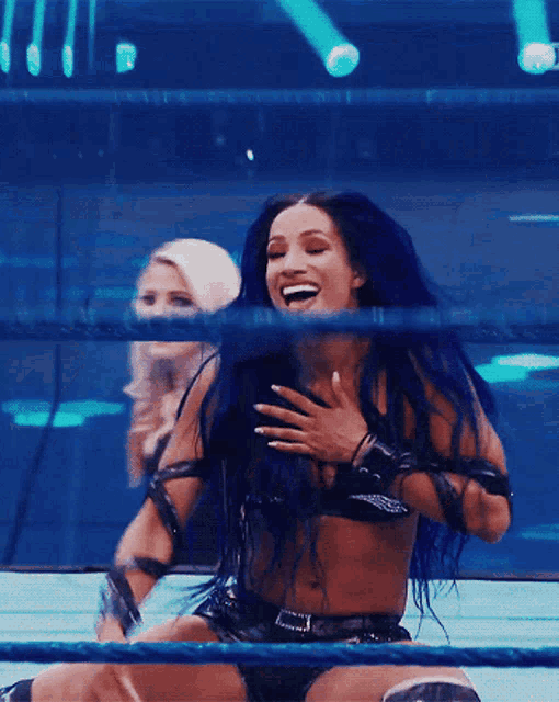 a wrestler with blue hair is laughing in a ring