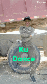 a man is dancing in front of a red truck with the words ku dance written on it