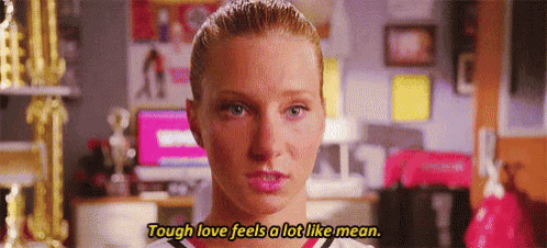a close up of a woman 's face with the words `` tough love feels a lot like mean '' written above her .