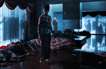 a woman standing in a room with a bunch of dead people on the floor