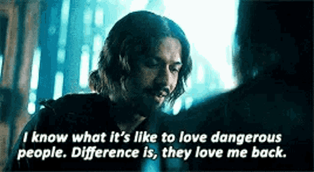 a man is talking to another man in a dark room with a quote .