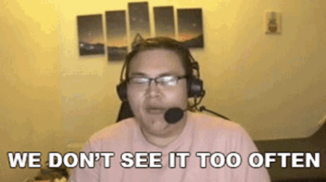 a man wearing headphones and a microphone is sitting in front of a computer .