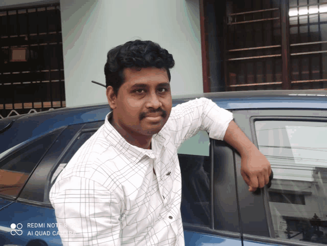 a man standing in front of a blue car with the words redmi note 8 ai quad camera on the bottom