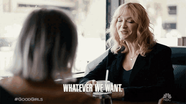 a woman is sitting at a table with a cup of coffee and says whatever we want