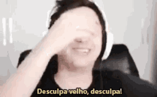 a man wearing headphones covering his face with his hand and the words desculpa velho desculpa