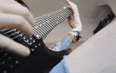 a person playing an electric guitar with a tattoo on their arm