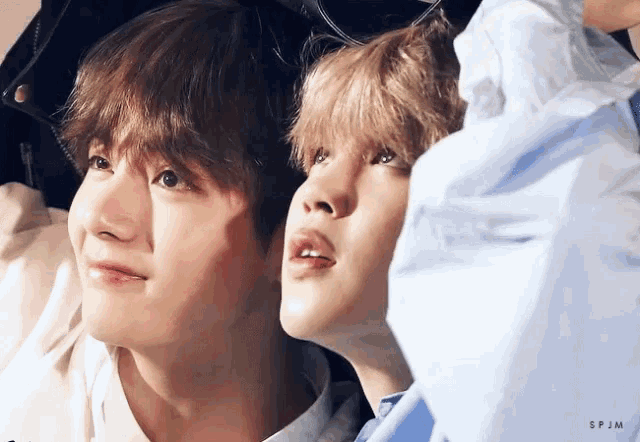 a close up of two young men 's faces looking up
