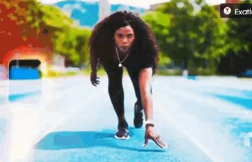a woman is getting ready to run on a track with an exotic logo in the corner