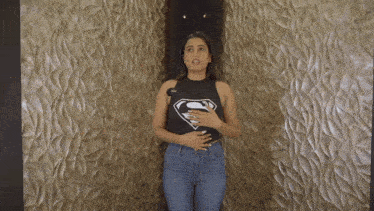 a woman is wearing a black shirt with a superman symbol on it