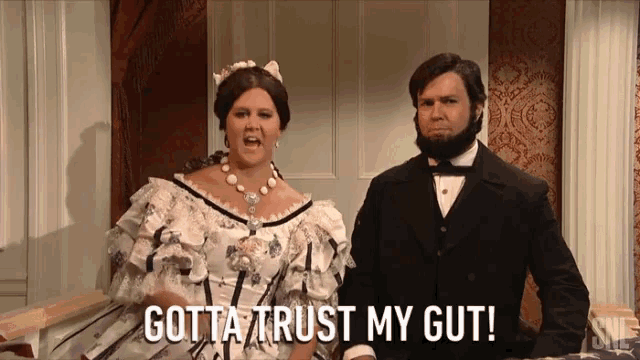 a man and a woman are standing next to each other with the words gotta trust my gut