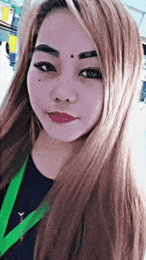 a close up of a woman 's face with a green lanyard around her neck with the letter y on it