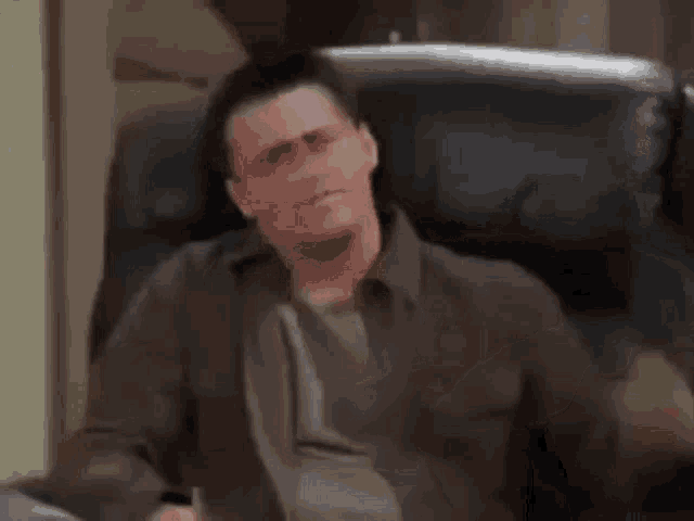 a man is sitting in a chair with his eyes closed and his mouth open .
