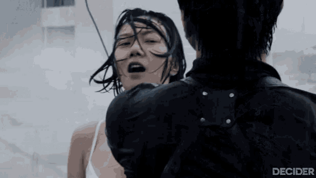 a man is holding a woman in his arms while she is screaming .