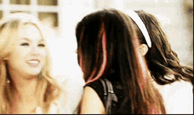 two women are talking to each other and one has red hair