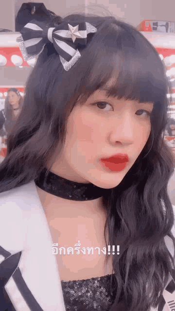a close up of a woman 's face with a choker and a bow in her hair