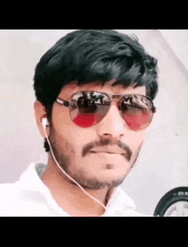 a man with a beard wearing sunglasses and earbuds
