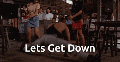 a group of people dancing in a room with the words lets get down