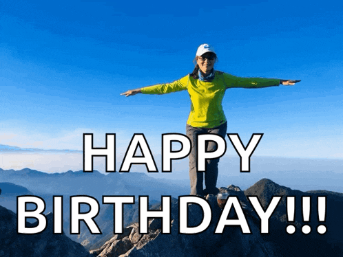 a woman stands on top of a mountain with her arms outstretched and says happy birthday !!!