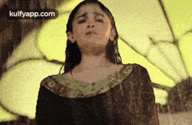 a woman is standing in the rain with her eyes closed and her hair wet .