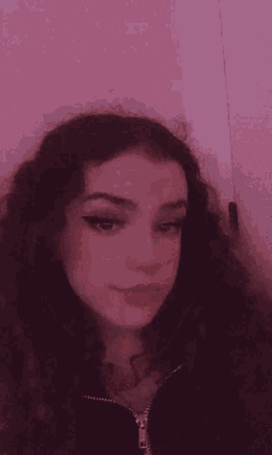 a close up of a girl 's face with a pink background and a pink background .