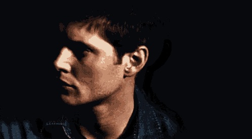a close up of a man 's face with a black background