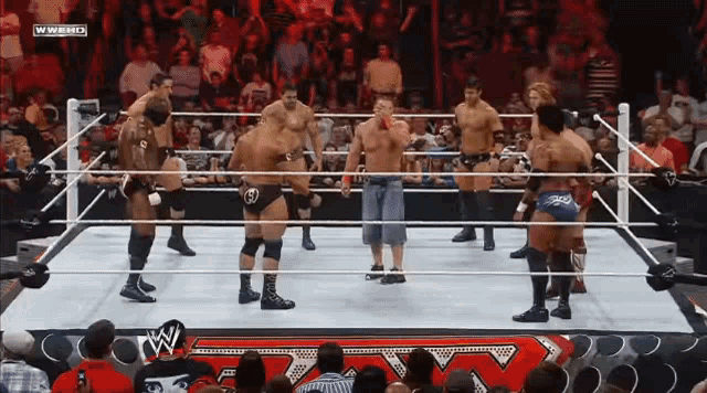 a group of wrestlers are in a ring with a w logo on the bottom