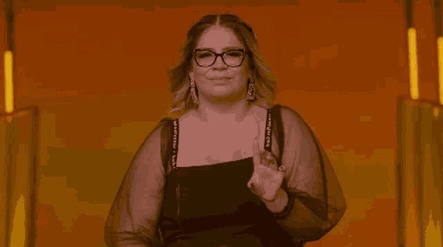 a woman wearing glasses and a black top that says " i love you "