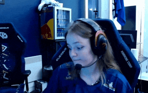 a woman wearing headphones is sitting in a chair that says karmine corp on it