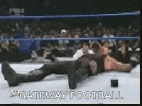 a man is laying on the ground in a wrestling ring with the words `` gateway football '' written on it .