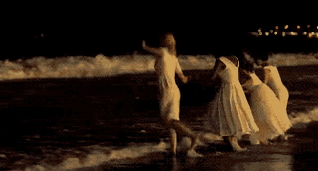 a group of women in white dresses are standing next to each other at night