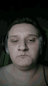 a man without a shirt is wearing headphones on his head