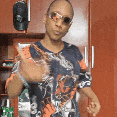 a man wearing sunglasses and a shirt with a dragon on it is giving a thumbs up