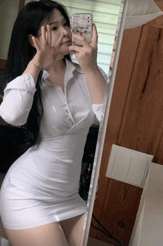 a woman taking a picture of herself in a mirror