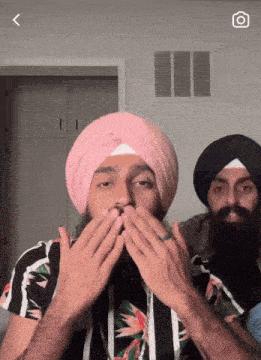 a man wearing a pink turban is covering his mouth