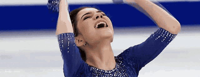 a woman in a blue dress with rhinestones on the sleeves is smiling