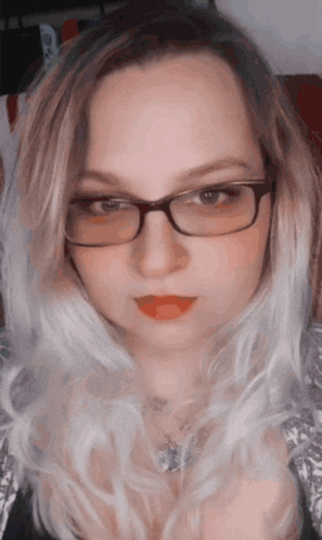 a close up of a woman wearing glasses and a necklace