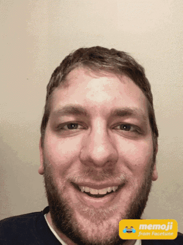a man with a beard is smiling in front of a yellow sign that reads memoji from facetune