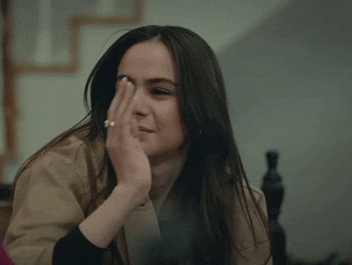 a woman with a ring on her finger is covering her face