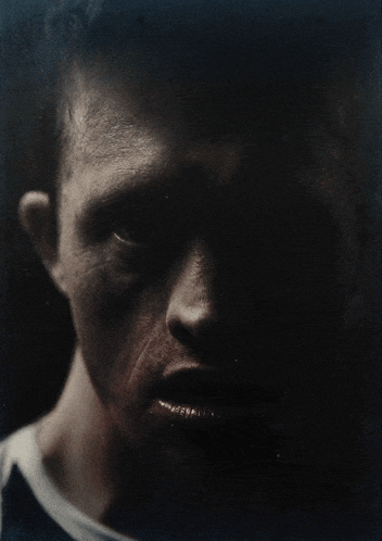 a close up of a man 's face with a white shirt on