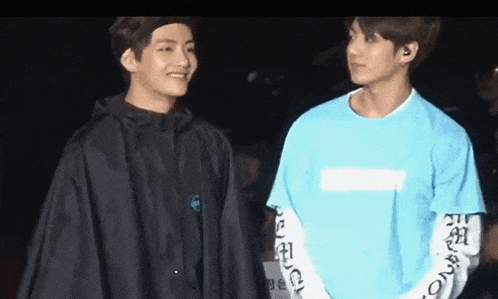 a couple of young men are standing next to each other on a stage .