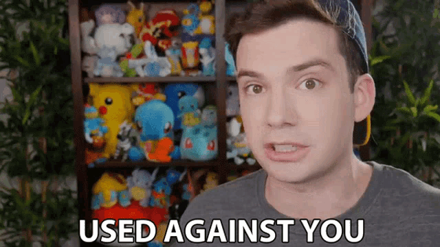 a man is standing in front of a shelf full of stuffed animals and says used against you