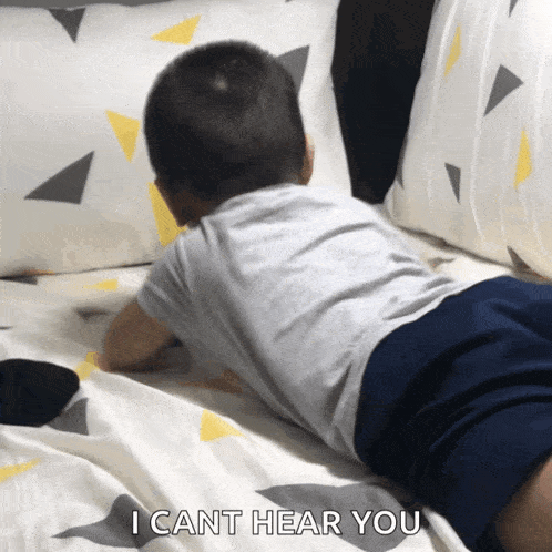 a child laying on a bed with the words " i cant hear you "