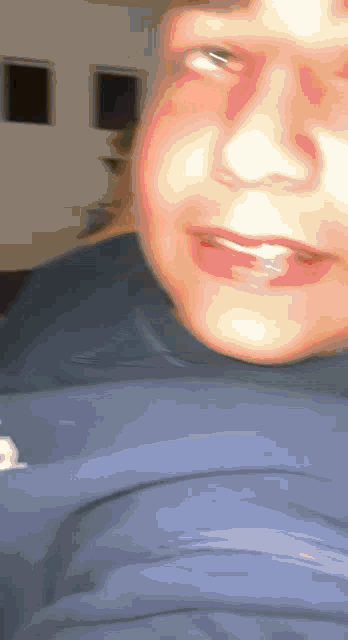 a blurry picture of a person 's face with a blue shirt on
