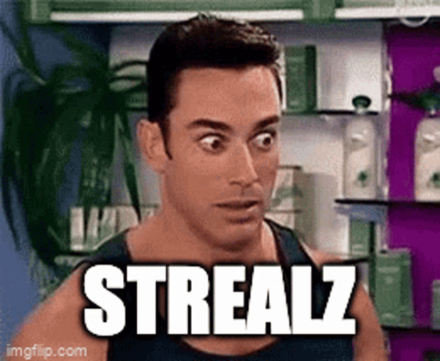 a man with a surprised look on his face is standing in front of a shelf with the word strealz on it .